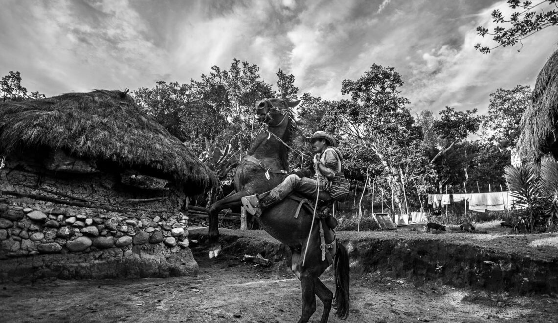 De repente, un hombre aparece cabalgando en la aldea: el rumor de la muerte del pequeño Juan ha corrido por el poblado y las personas comienzan a llegar a la casa para el inicio del funeral.
Nabusimake, Colombia, 16 de septiembre, 2018